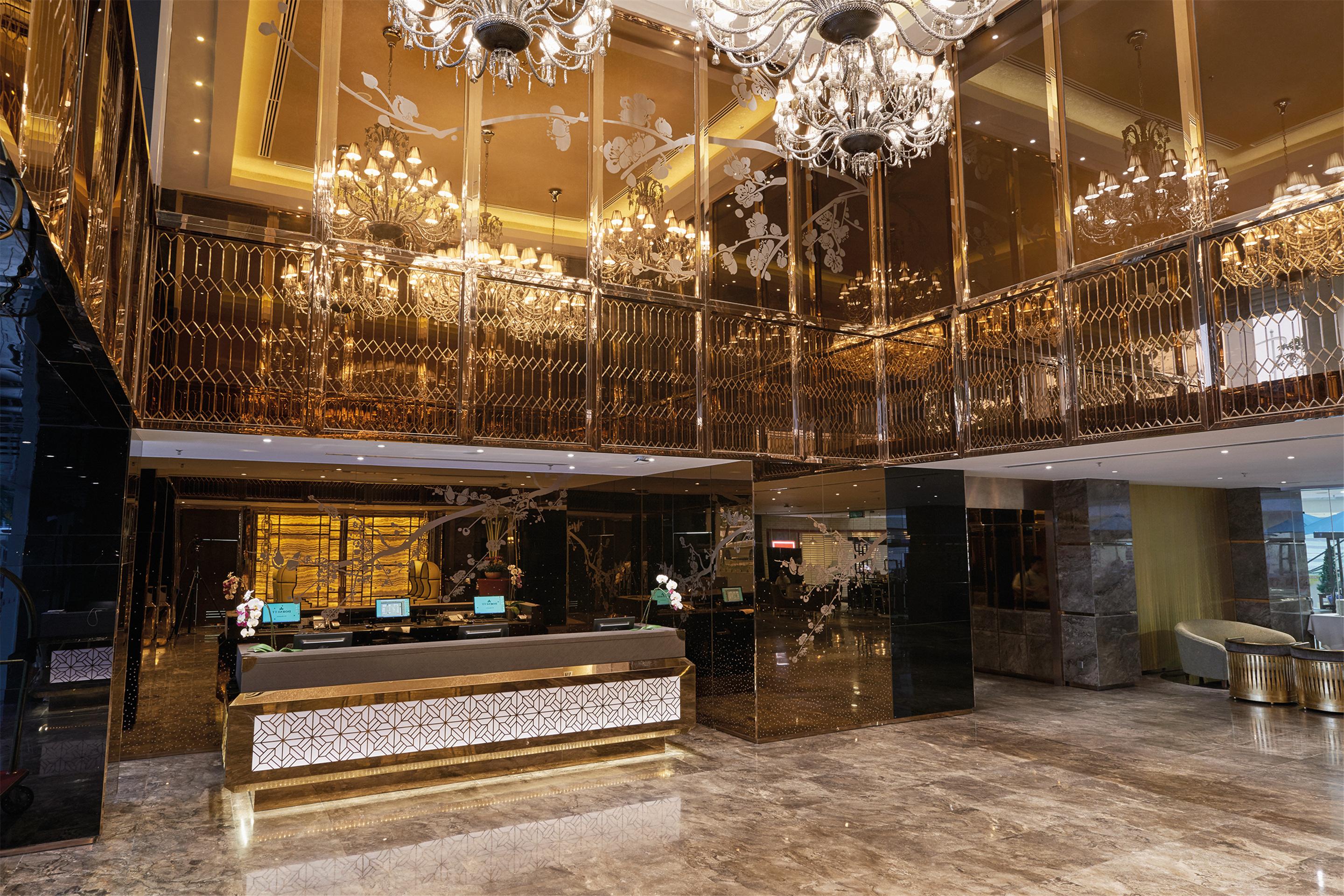 Dorsett Putrajaya Hotel Exterior photo The photo shows a luxurious hotel lobby characterized by an opulent design. The space features high ceilings adorned with ornate chandeliers that provide elegant lighting. The lobby has a polished floor with a lustrous finish, and the walls are embel