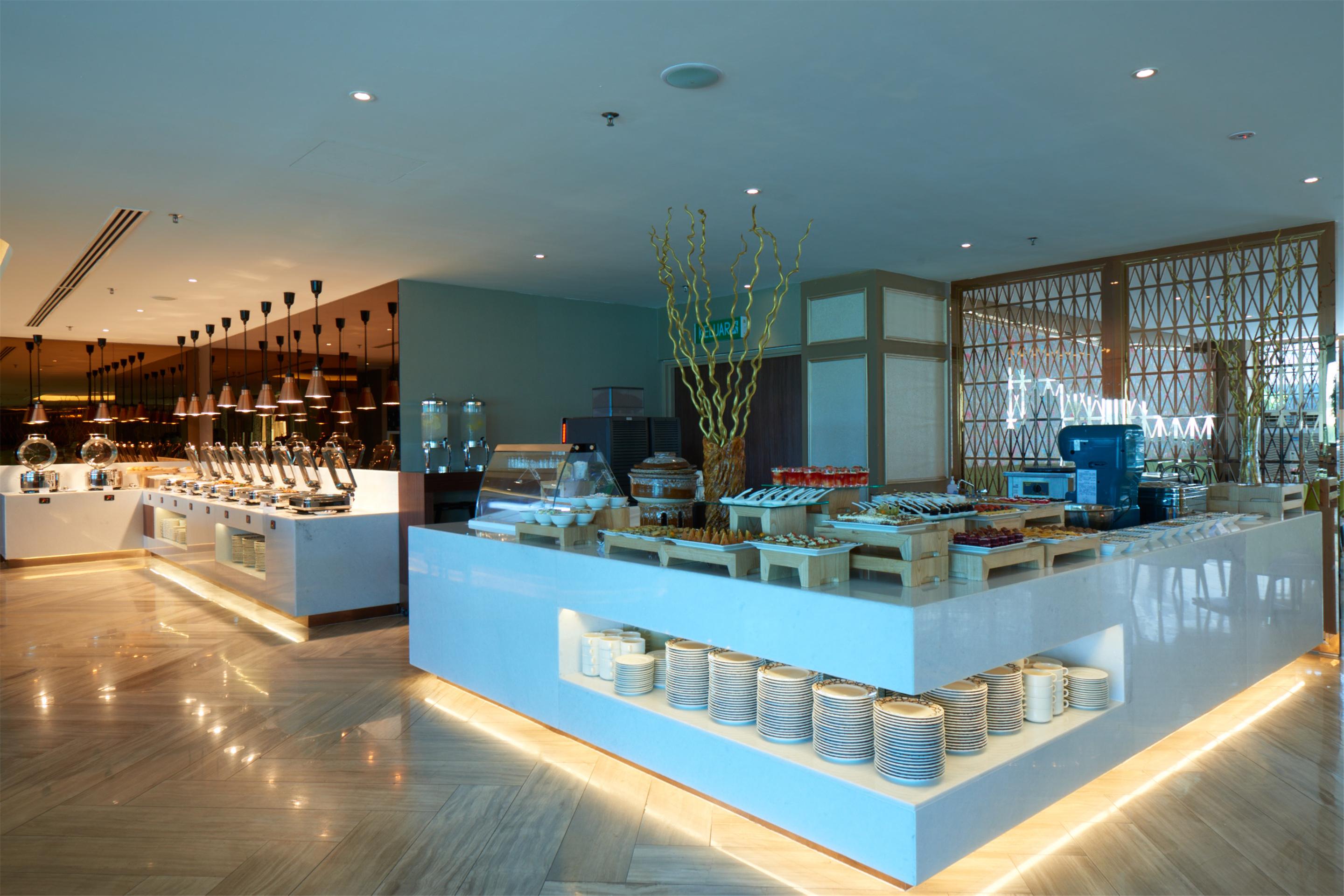Dorsett Putrajaya Hotel Exterior photo The photo showcases a modern buffet-style restaurant interior. There are multiple food stations with neatly arranged dishes and an organized layout. The decor includes elegant lighting and contemporary design elements, creating a welcoming atmosphere