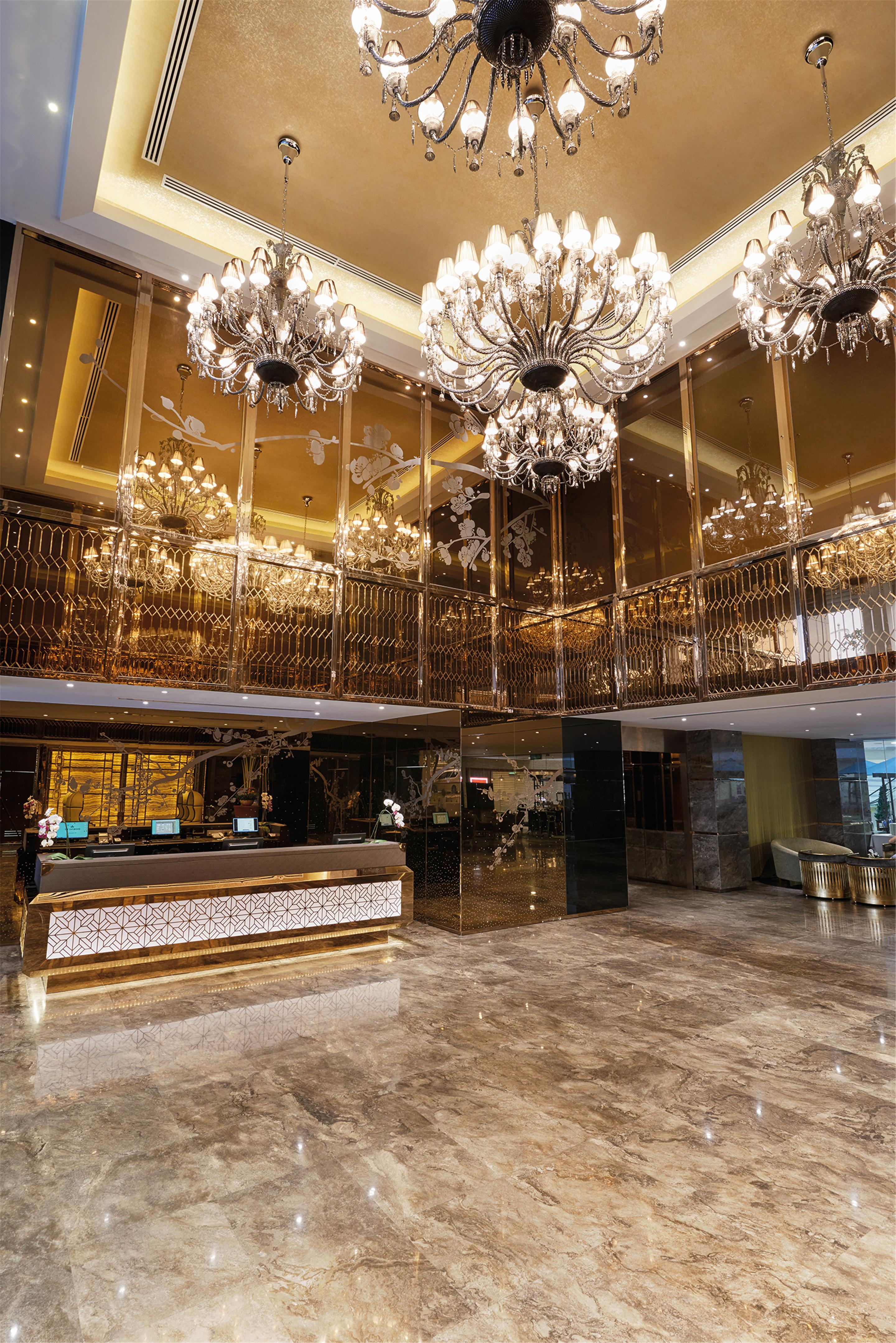 Dorsett Putrajaya Hotel Exterior photo The photo shows a luxurious hotel lobby interior. It features a grand design with golden accents and elegant chandeliers hanging from the ceiling. The reception area has a stylish desk with decorative details, and the surrounding space is adorned wit