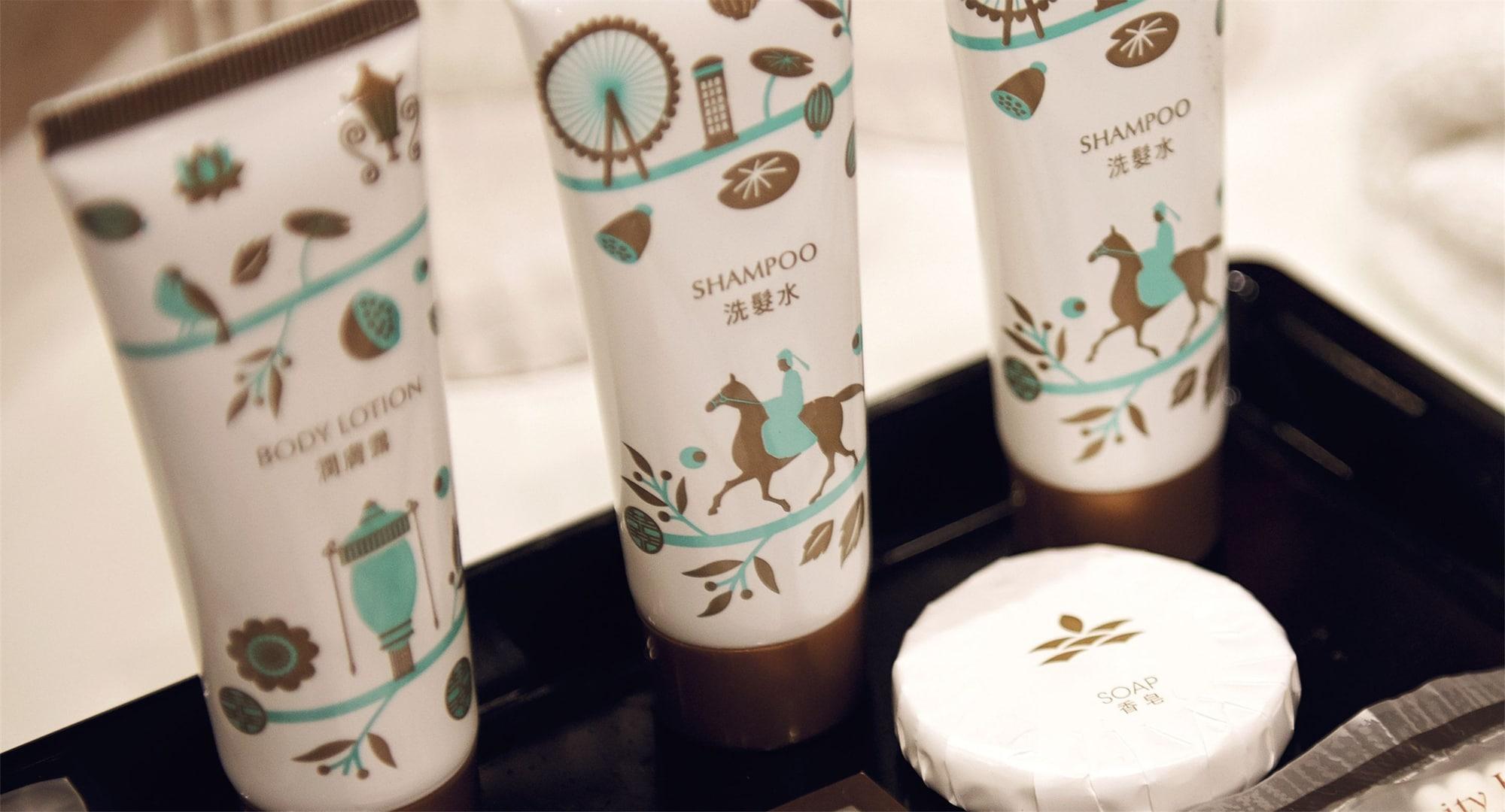Dorsett Putrajaya Hotel Exterior photo The photo shows a set of personal care products on a black tray. There are three tubes with decorative designs, including illustrations of horses and flora. The tubes are labeled as "Shampoo" and "Body Lotion." Next to the tubes, there is a round bar