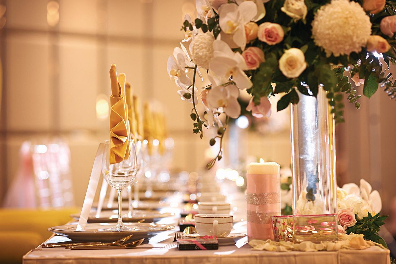 Dorsett Putrajaya Hotel Exterior photo The photo shows a beautifully arranged dining table, likely set for a special event or celebration. There are elegant place settings with glassware, neatly folded napkins, and decorative elements. A striking floral centerpiece featuring white orchids