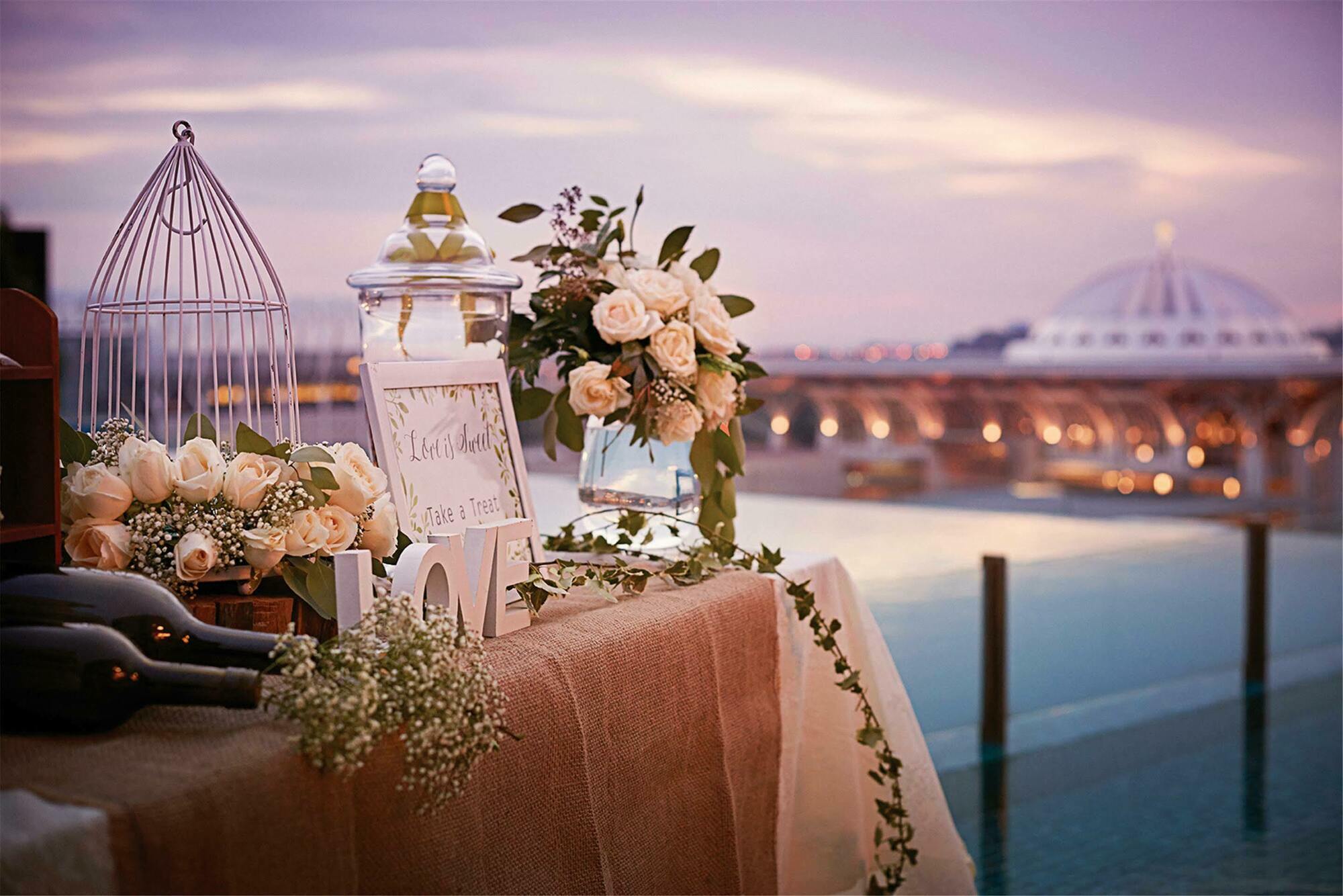 Dorsett Putrajaya Hotel Exterior photo The photo depicts a beautifully arranged outdoor setting with a table elegantly decorated for an event, possibly a wedding or special occasion. 

- **Floral Arrangements**: There are various floral arrangements, including soft-colored roses and green